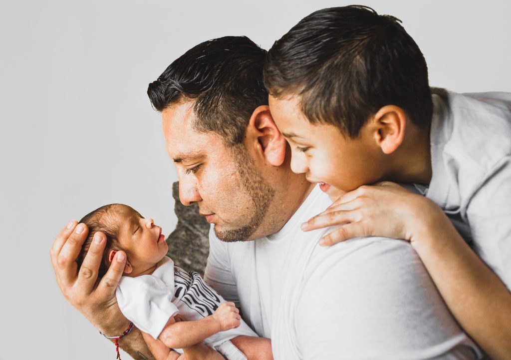 father and son holding new baby suffering from birth injury Merson Law PLLC