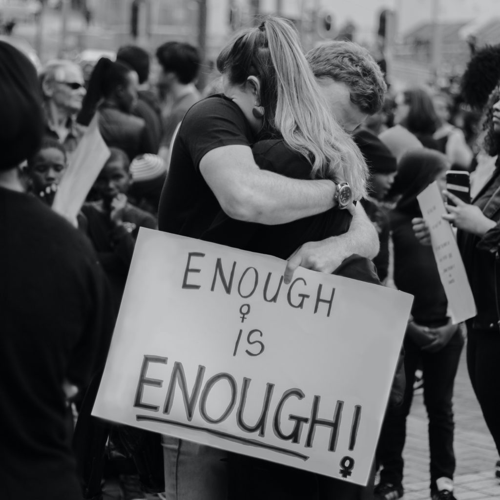 victims protesting gender-motivated violence embrace