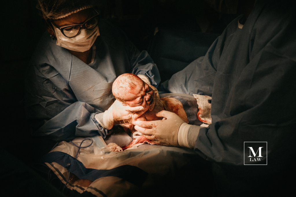 infant being delivered via c-section