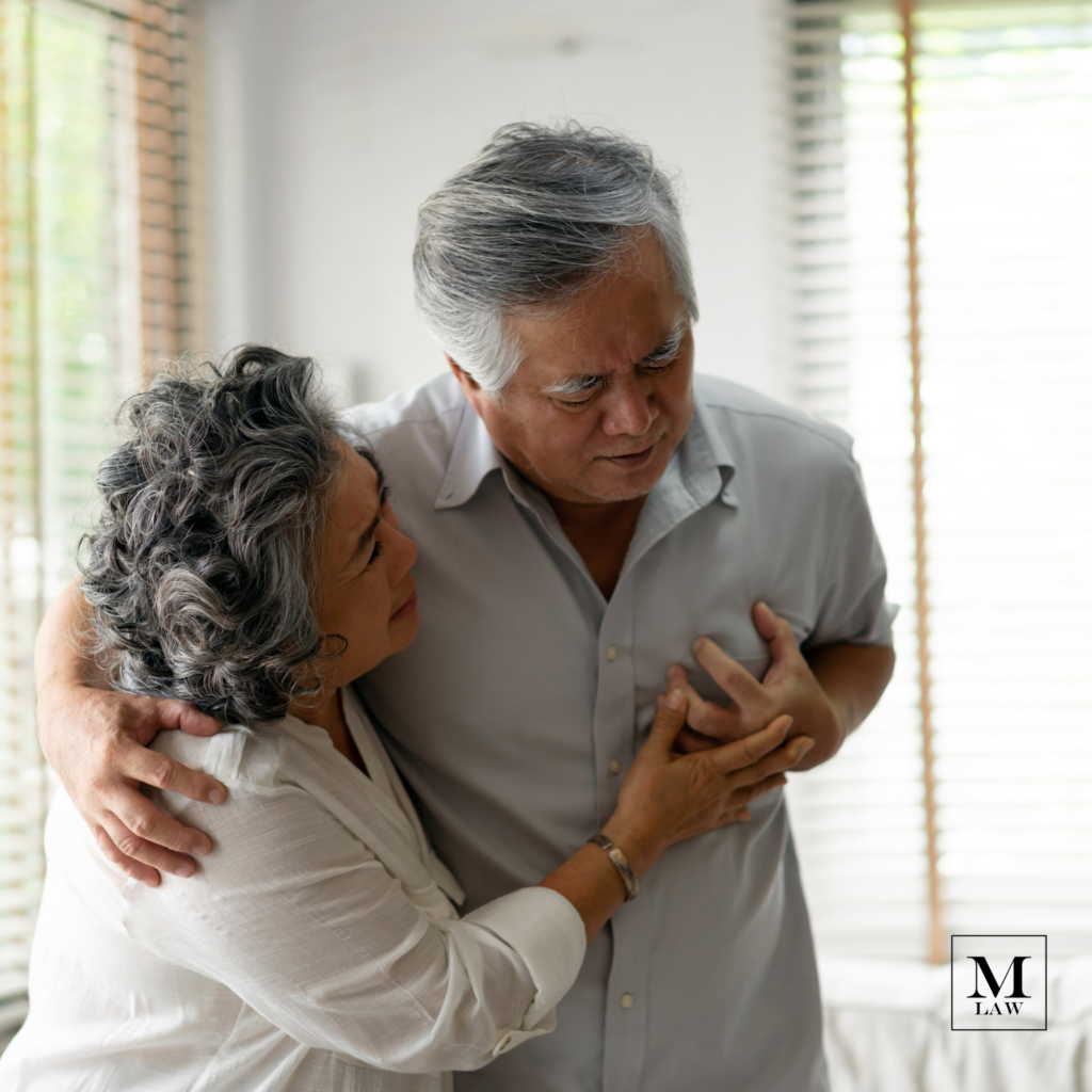 man clutching chest, experiencing symptoms of a heart attack